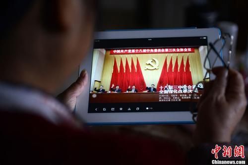 資料圖：一位網(wǎng)友用平板電腦瀏覽有關(guān)中國共產(chǎn)黨十八屆三中全會的報道。<a target=